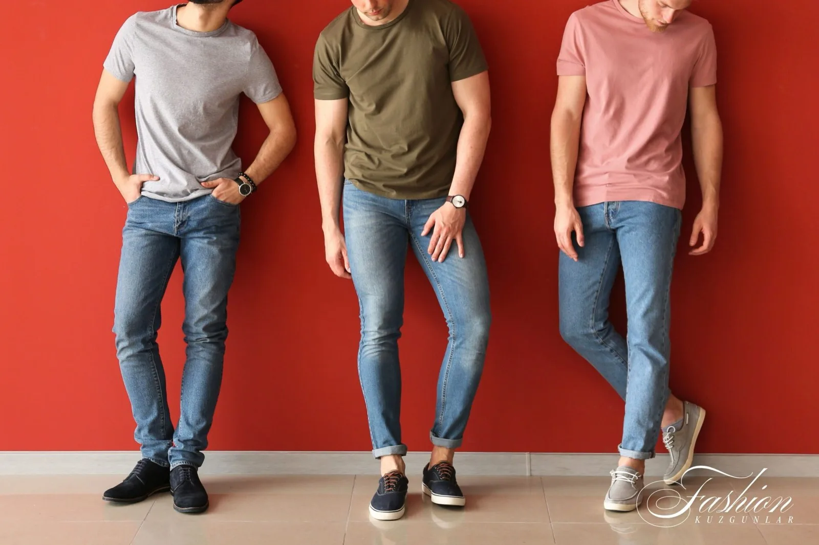 Three men wearing light-wash slim jeans against a red wall